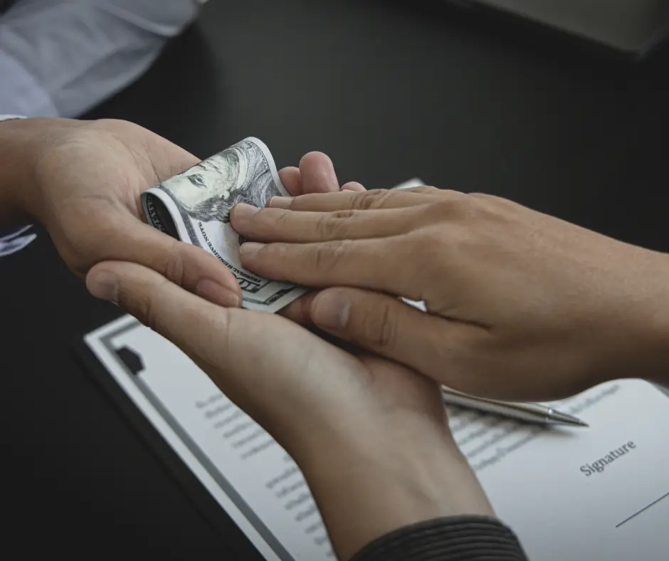 Hand exchanging cash over a contract.
