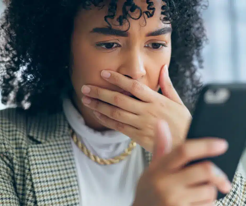Woman looking shocked at phone.