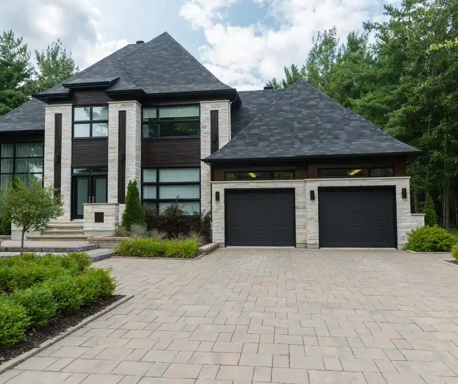 a house with a driveway and trees, an example of roofing services in fort garry