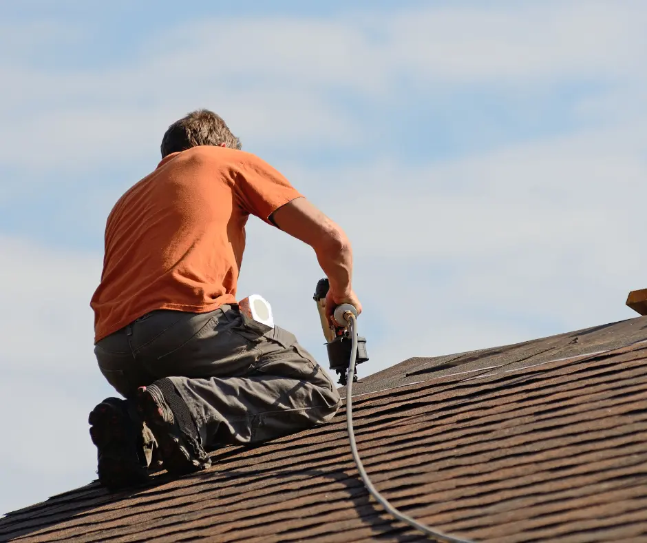 A person repairing a roof as part of a roof maintenance for summer