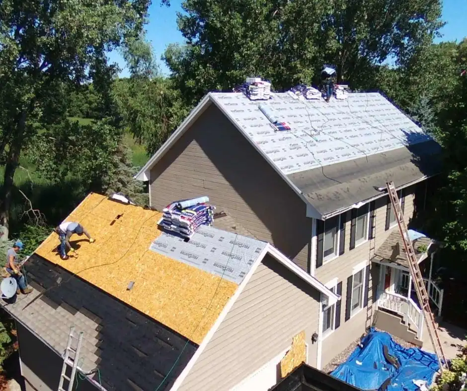 A view from above showing two people on the roof of a house, which is being worked on.