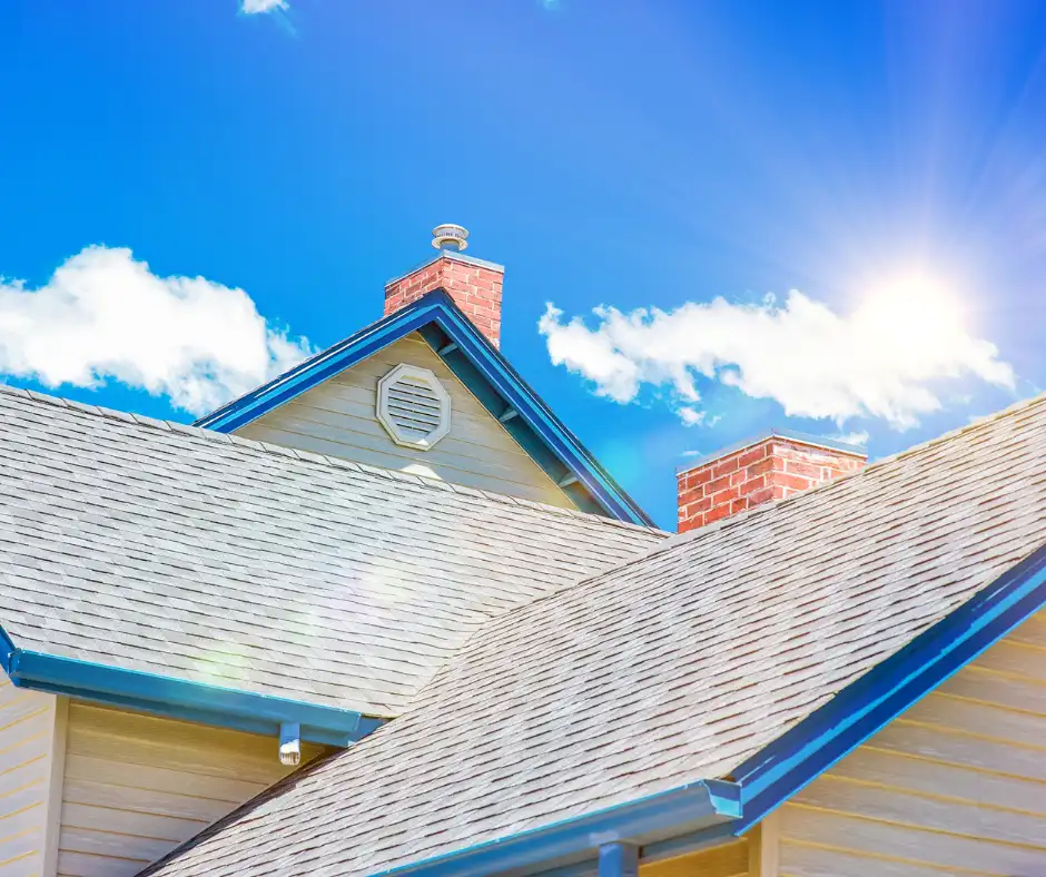 A close-up of a house roof under a sunny sky.