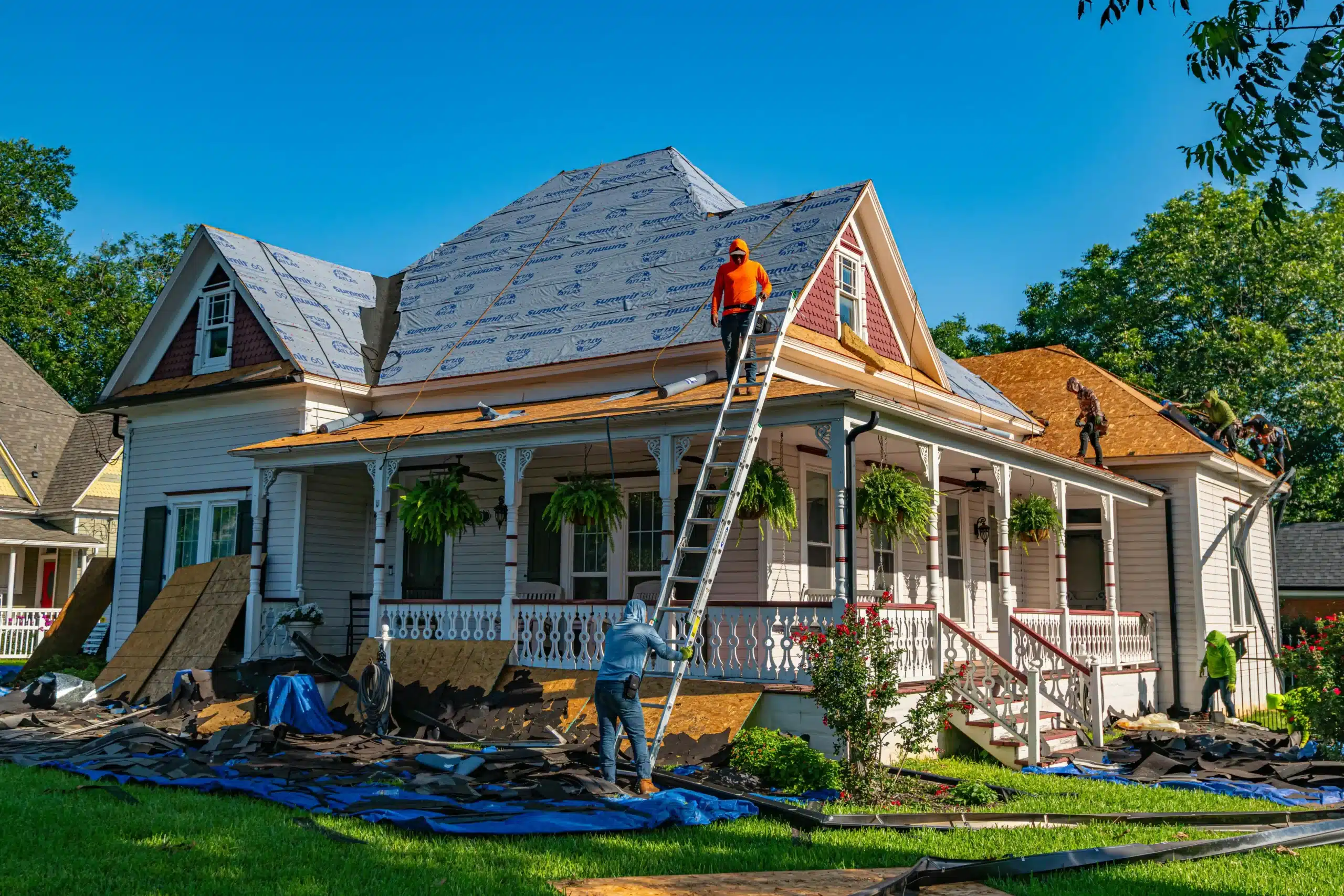 Roofers working on a house for roof replacement in Summer.
