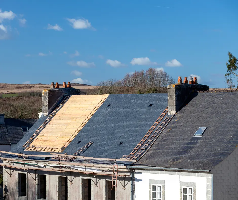 Roofer working on removing and replacing roofing materials on a home, roof repair vs roof replacement