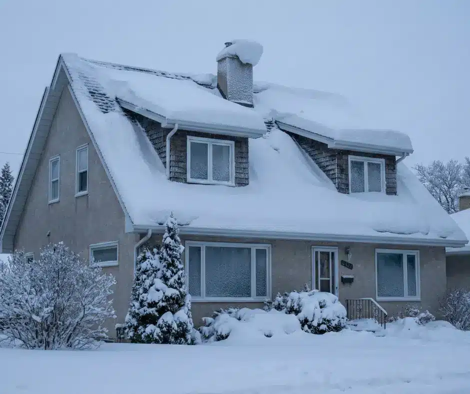 House with steep roof covered in deep winter snow.