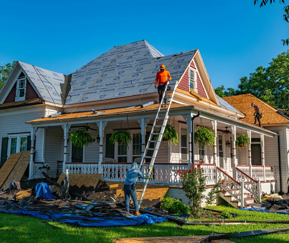A professional crew performing bundled exterior work, including the installation of high-quality underlayment and shingles, on a large residential home renovation.
